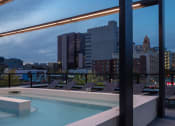 Thumbnail 11 of 40 - a view of the city from the rooftop of a building with a pool at Maven on Broadway, Rochester, MN