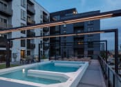 Thumbnail 35 of 40 - a pool in front of an apartment building at night at Maven on Broadway, Rochester, Minnesota