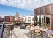 Thumbnail 23 of 40 - a balcony with tables and chairs and a view of the city at Maven on Broadway, Rochester, MN, 55904