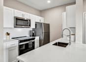 Thumbnail 1 of 30 - a kitchen with white cabinets and stainless steel appliances at Stonelake at the Arboretum, Austin, TX, 78759