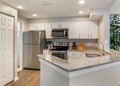 Thumbnail 6 of 41 - A kitchen with white countertops and stainless steel appliances at Floresta apartments in Jupiter, FL