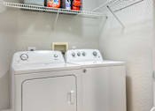 Thumbnail 15 of 41 - A white washing machine and dryer in a small laundry room.