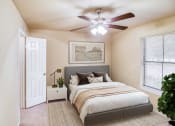 Thumbnail 13 of 31 - a bedroom with a large bed and a ceiling fan at Village Oaks Apartments, Texas, 78759