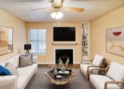 Thumbnail 12 of 31 - a living room with white couches and chairs and a fireplace with a flat screen tv above at Village Oaks Apartments, Austin, Texas