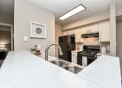 Thumbnail 22 of 25 - a kitchen with white countertops and a large white island with a stainless steel sink at 670 Thornton, Lithia Springs
