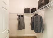 Thumbnail 5 of 36 - a closet with clothes hanging on a rack and a door at Estate at Woodmen Ridge, Colorado Springs