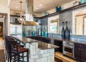 Thumbnail 17 of 36 - a kitchen with a large counter and chairsat Estate at Woodmen Ridge, Colorado Springs, CO