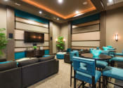 Thumbnail 15 of 36 - a lounge area with blue chairs and couches and a television at Estate at Woodmen Ridge, Colorado