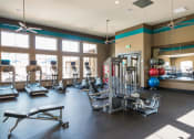 Thumbnail 9 of 36 - a gym with weights and cardio equipment and windows at Estate at Woodmen Ridge, Colorado Springs, 80923