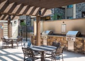 Thumbnail 31 of 36 - a patio with a table and chairs and a grill at Estate at Woodmen Ridge, Colorado Springs, 80923