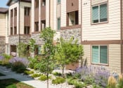 Thumbnail 8 of 36 - a row of apartment buildings with a sidewalk in front of them at Estate at Woodmen Ridge, Colorado Springs, CO