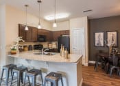 Thumbnail 1 of 36 - an open kitchen and dining area with stools and a granite counter top at Estate at Woodmen Ridge, Colorado, 80923