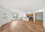 Thumbnail 1 of 50 - A spacious room with wooden flooring and white walls.
