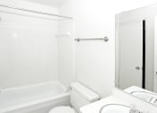 Thumbnail 11 of 12 - a white bathroom with a tub and a sink and a toilet
