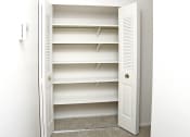 Thumbnail 9 of 12 - an empty closet with empty shelves in a bathroom