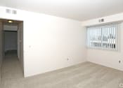Thumbnail 6 of 12 - an empty living room with a large window and white walls