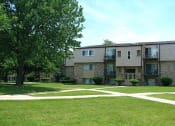 Thumbnail 2 of 12 - an exterior view of an apartment building with grass and trees
