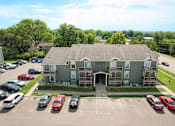 Thumbnail 2 of 16 - A parking lot with cars and a building in the background.