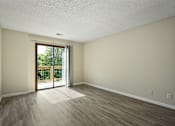 Thumbnail 11 of 16 - A room with a sliding glass door leading to a backyard.