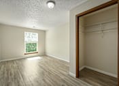 Thumbnail 10 of 16 - A room with a window and a wooden floor.