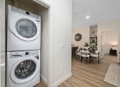 Thumbnail 7 of 21 - a washer and dryer in a living room next to a dining room table