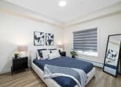 Thumbnail 6 of 21 - a bedroom with a large bed and a window with a blue blanket