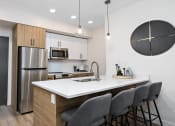 Thumbnail 2 of 21 - a kitchen with a large island and a stainless steel refrigerator