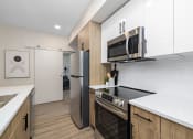 Thumbnail 3 of 21 - a kitchen with a stove and a microwave
