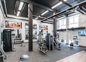 Thumbnail 18 of 21 - A gym with a variety of equipment including treadmills, weights, and exercise machines.