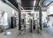 Thumbnail 19 of 21 - A gym with a variety of equipment including treadmills, weights, and exercise bikes.