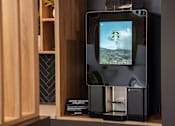 Thumbnail 17 of 21 - A coffee machine with a screen showing a green landscape.
