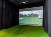 Thumbnail 14 of 21 - A golf simulator screen shows a course with a flag on the green.