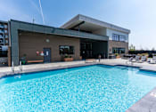Thumbnail 3 of 21 - A large swimming pool in front of a modern building.