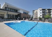 Thumbnail 10 of 21 - a large swimming pool in front of an apartment building