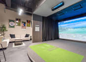 Thumbnail 16 of 21 - a room with a projector screen and couches and a green rug