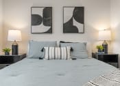 Thumbnail 8 of 21 - a bedroom with a bed and two paintings on the wall