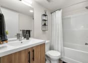Thumbnail 11 of 21 - a bathroom with a sink and a toilet and a shower