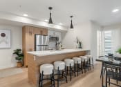 Thumbnail 2 of 21 - an open kitchen and dining area with a bar and stools