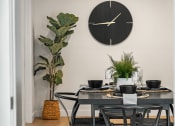 Thumbnail 4 of 21 - a dining room with a table and a clock on the wall