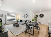 Thumbnail 5 of 21 - A modern living room with a grey sofa, a black coffee table, and a grey rug.
