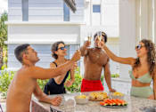 Thumbnail 26 of 27 - A group of people toasting with champagne at a barbecue.at Icon One, Florida, 32114