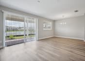 Thumbnail 43 of 48 - the living room of an apartment with a large window and a sliding glass door