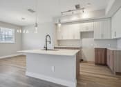 Thumbnail 38 of 48 - an open kitchen with a large white island and white cabinets
