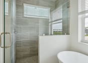 Thumbnail 11 of 48 - a bathroom with a shower and a sink and a window