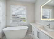 Thumbnail 10 of 48 - a bathroom with a tub and a sink and a window