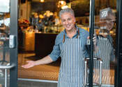 Thumbnail 8 of 11 - Shop owner standing in the door to his store