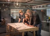 Thumbnail 9 of 11 - Business professionals viewing plans on a table