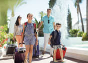 Thumbnail 44 of 48 - a family is walking with their luggage at a resort