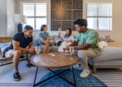 Thumbnail 21 of 27 - Four people sitting on a couch and a table in front of them.at Icon One, Daytona Beach, Florida
