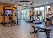 Thumbnail 4 of 27 - A man is working out on a machine in a gym with other people exercising in the background.at Icon One, Florida, 32114